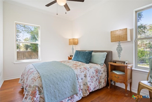 bedroom with ceiling fan, crown molding, and wood-type flooring