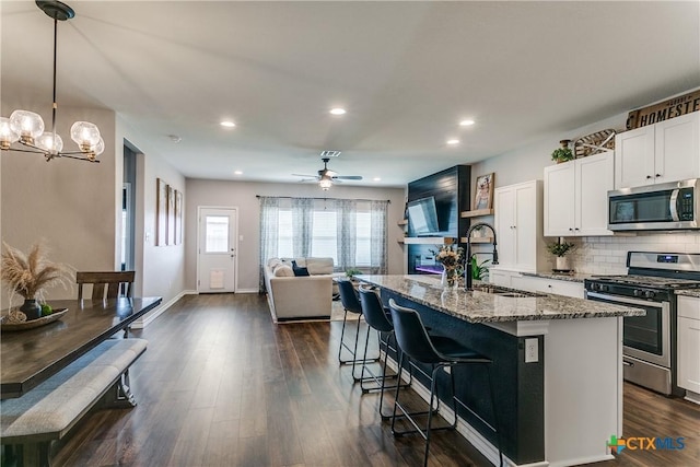 391 Walnut Crk, New Braunfels, TX 78130 - kitchen with appliances with stainless steel finishes, a sink, stone countertops, a kitchen island with sink, and white cabinetry