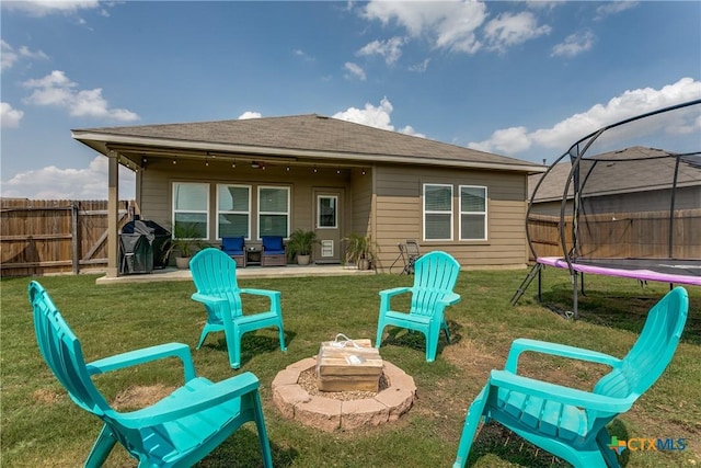 391 Walnut Crk, New Braunfels, TX 78130 - back of property with a trampoline, an outdoor fire pit, and a patio area