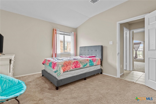 bedroom featuring light colored carpet and vaulted ceiling