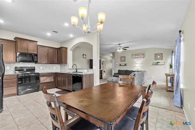 dining space featuring lofted ceiling, ceiling fan with notable chandelier, light tile patterned floors, and sink