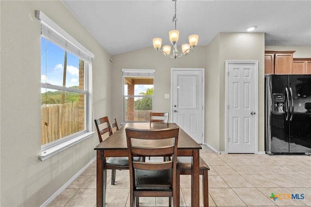 dining room featuring light tile patterned flooring, lofted ceiling, and a notable chandelier