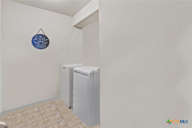 laundry area featuring light tile patterned floors and separate washer and dryer