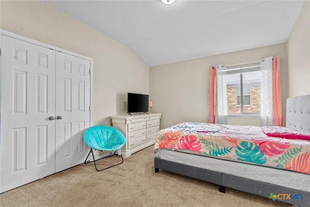 carpeted bedroom featuring a closet and vaulted ceiling