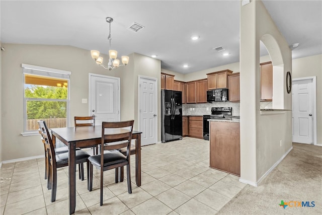 kitchen featuring black appliances, pendant lighting, lofted ceiling, and light tile patterned flooring