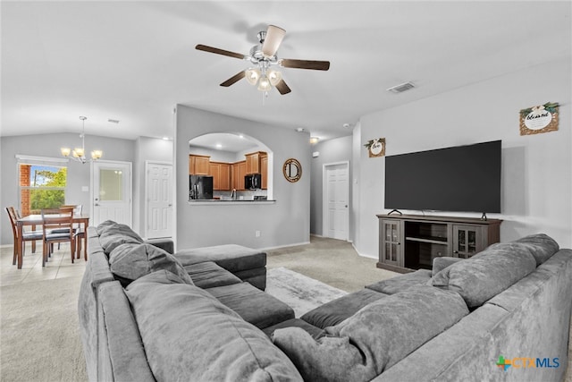 carpeted living room featuring vaulted ceiling and ceiling fan with notable chandelier