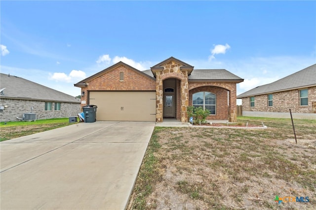 view of front of property featuring a garage, cooling unit, and a front lawn