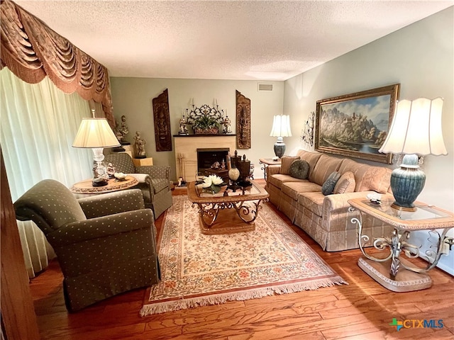 living room with wood-type flooring and a textured ceiling