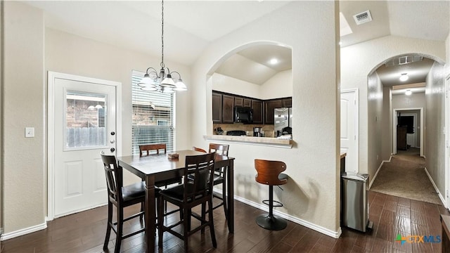 557/561 Creekside Cir, New Braunfels, TX 78130 - dining area featuring arched walkways, lofted ceiling, dark wood finished floors, and a chandelier