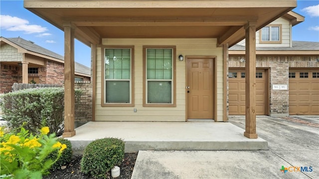 557/561 Creekside Cir, New Braunfels, TX 78130 - property entrance with driveway, a garage, and covered porch