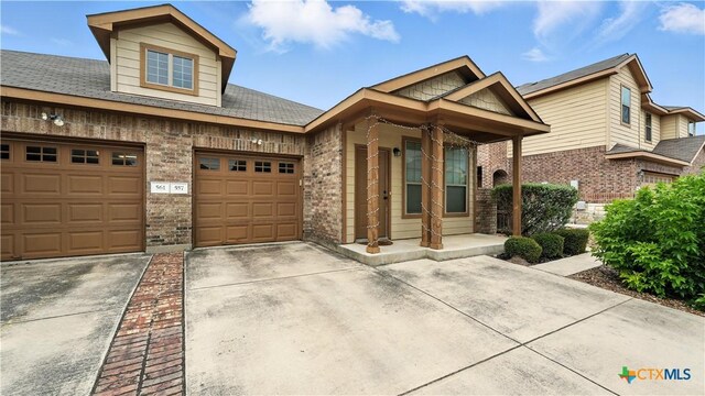 557/561 Creekside Cir, New Braunfels, TX 78130 - view of front of house featuring concrete driveway, brick siding, and covered porch