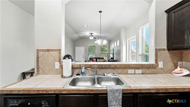 557/561 Creekside Cir, New Braunfels, TX 78130 - kitchen featuring dishwashing machine, tile counters, ceiling fan, vaulted ceiling, and a textured wall