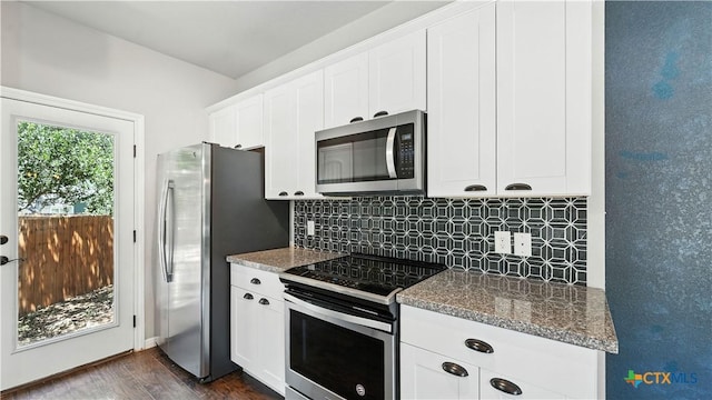 543 Scenic Terrace Dr, Canyon Lake, TX 78133 - kitchen featuring appliances with stainless steel finishes, decorative backsplash, dark wood-style floors, white cabinetry, and dark stone countertops