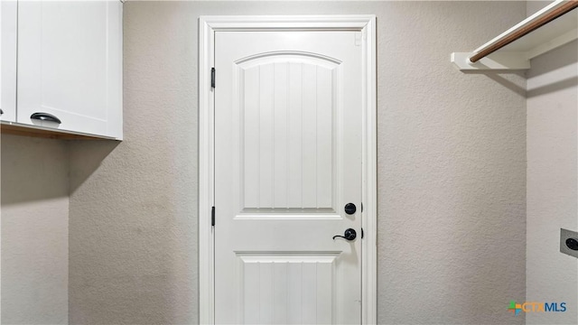 543 Scenic Terrace Dr, Canyon Lake, TX 78133 - washroom featuring cabinet space, electric dryer hookup, and a textured wall