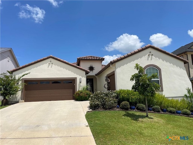 mediterranean / spanish house with a garage and a front yard