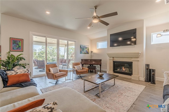 living room featuring vaulted ceiling, ceiling fan, and light wood-type flooring