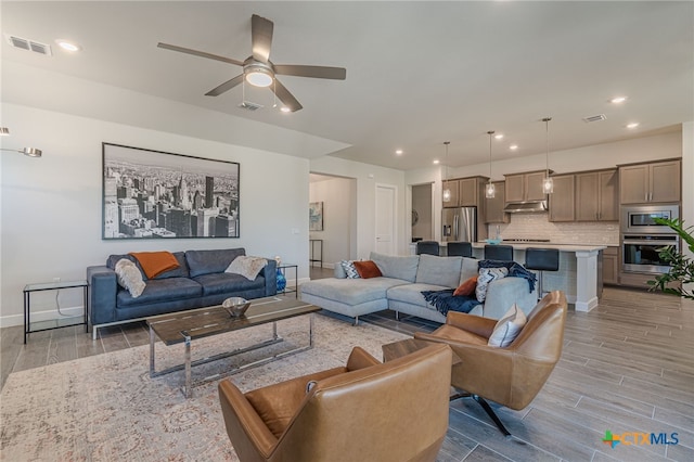 living room featuring ceiling fan and light hardwood / wood-style flooring