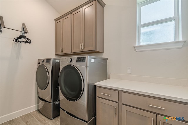 laundry room featuring washer and dryer and cabinets