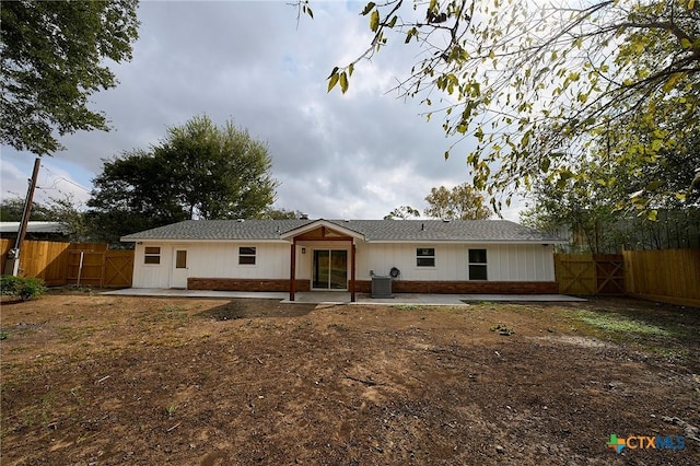 back of property with central AC unit and a patio