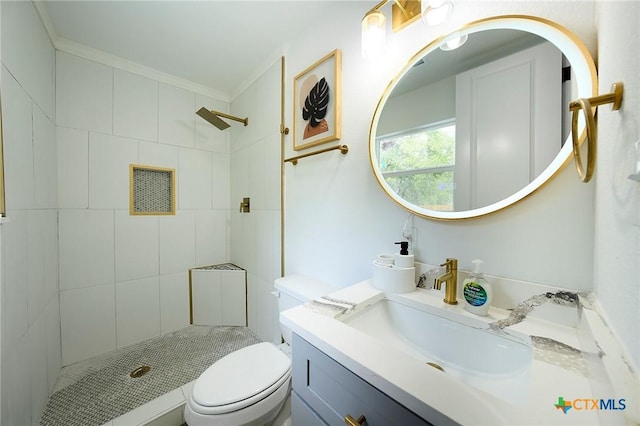 bathroom featuring crown molding, vanity, toilet, and a tile shower