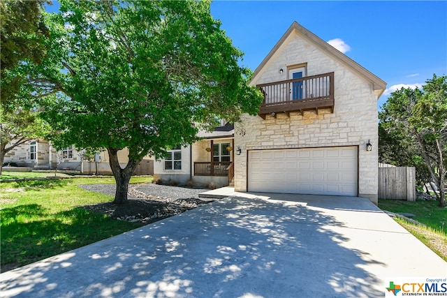 view of front of property with a balcony, a front yard, and a garage