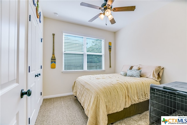 bedroom featuring ceiling fan, light carpet, and a closet