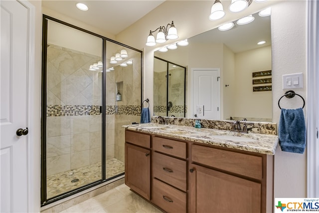 bathroom with tile patterned flooring, vanity, and a shower with door