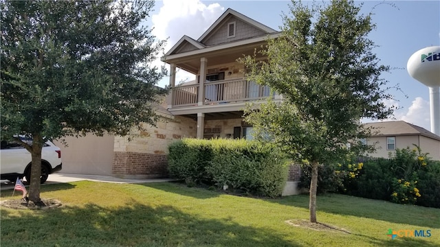 view of front of home with a balcony and a front yard