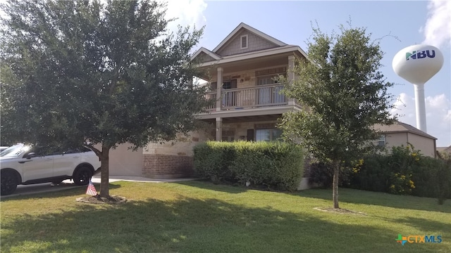 view of front of home featuring a front lawn and a balcony