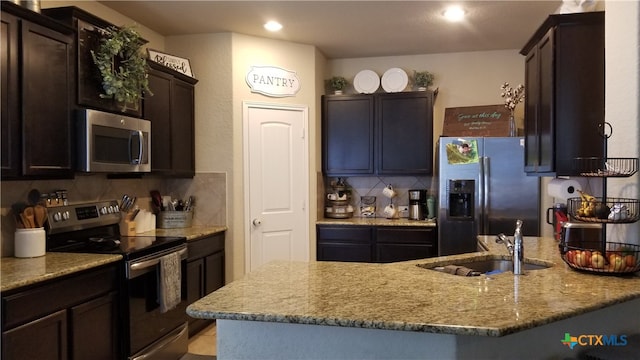 kitchen featuring dark brown cabinetry, sink, appliances with stainless steel finishes, tasteful backsplash, and light stone countertops