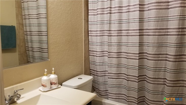 bathroom with sink, toilet, and a shower with curtain