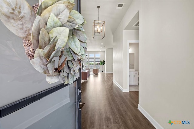 hall featuring dark hardwood / wood-style flooring and a notable chandelier