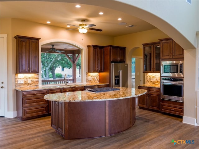 kitchen with dark wood-type flooring, a kitchen island, sink, and stainless steel appliances