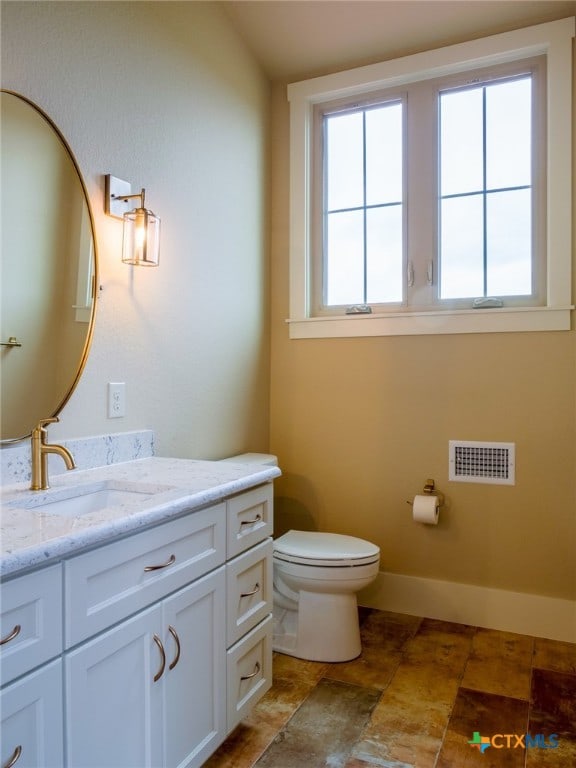 bathroom with vanity, plenty of natural light, and toilet