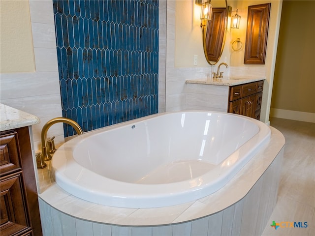 bathroom with vanity and tiled bath