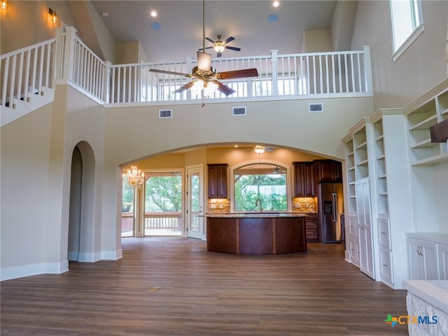 kitchen featuring a center island, a towering ceiling, backsplash, dark hardwood / wood-style floors, and high end fridge