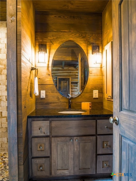 bathroom with wood walls and vanity