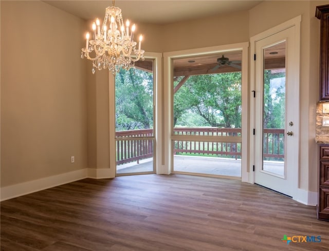 interior space featuring a wealth of natural light, wood-type flooring, and ceiling fan with notable chandelier