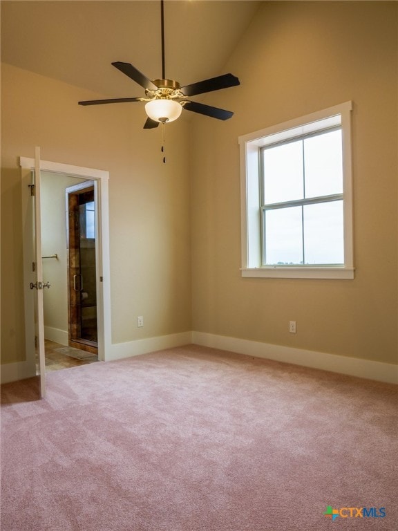 carpeted spare room featuring ceiling fan and high vaulted ceiling