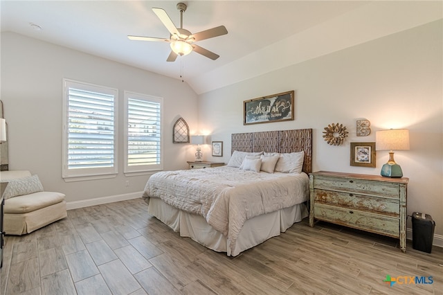 bedroom with ceiling fan, light wood-type flooring, and lofted ceiling