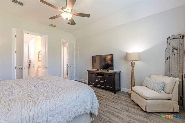 bedroom with ceiling fan, ensuite bath, lofted ceiling, and hardwood / wood-style floors