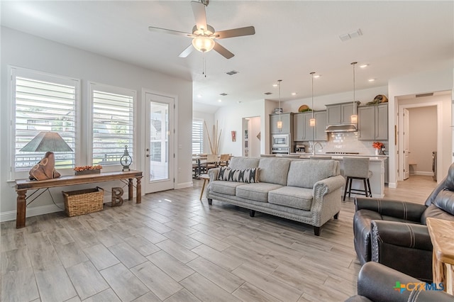 living room with ceiling fan and sink