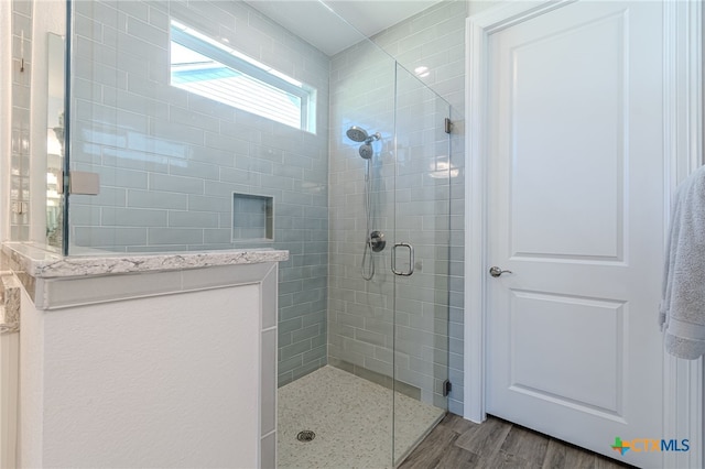 bathroom featuring wood-type flooring and walk in shower