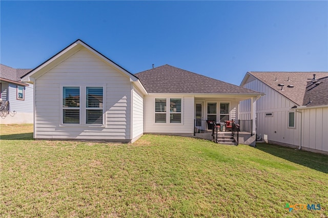 back of house with covered porch and a yard