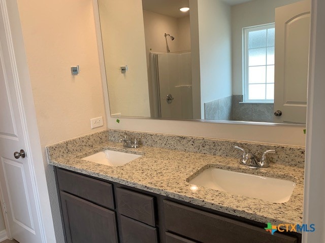 bathroom featuring a shower and vanity