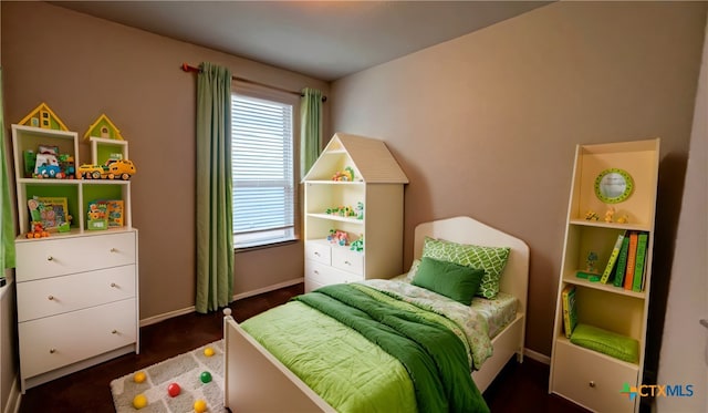 bedroom with dark hardwood / wood-style floors