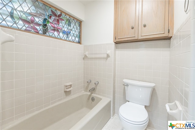 bathroom featuring toilet, tile walls, and a healthy amount of sunlight