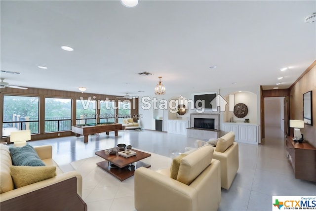 living room with ceiling fan, crown molding, billiards, and a tiled fireplace