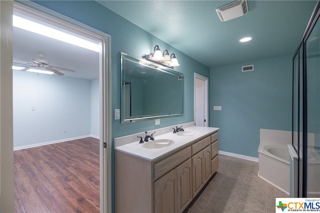 bathroom with a tub to relax in, vanity, hardwood / wood-style flooring, and ceiling fan