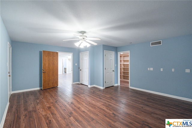 spare room featuring a textured ceiling, ceiling fan, and dark wood-type flooring